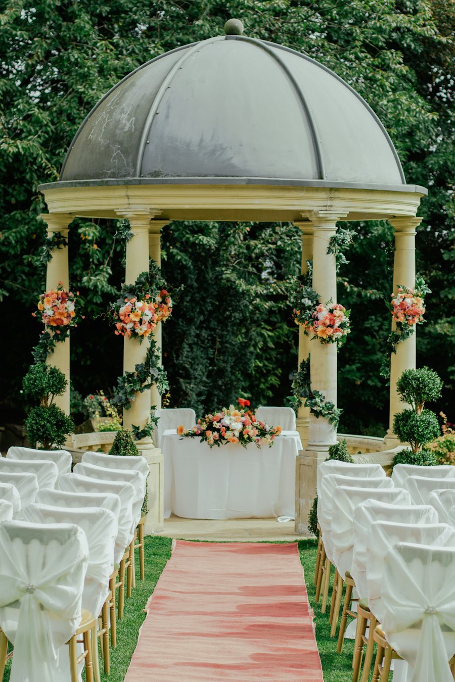 Garden wedding ceremony with a flower-covered gazebo